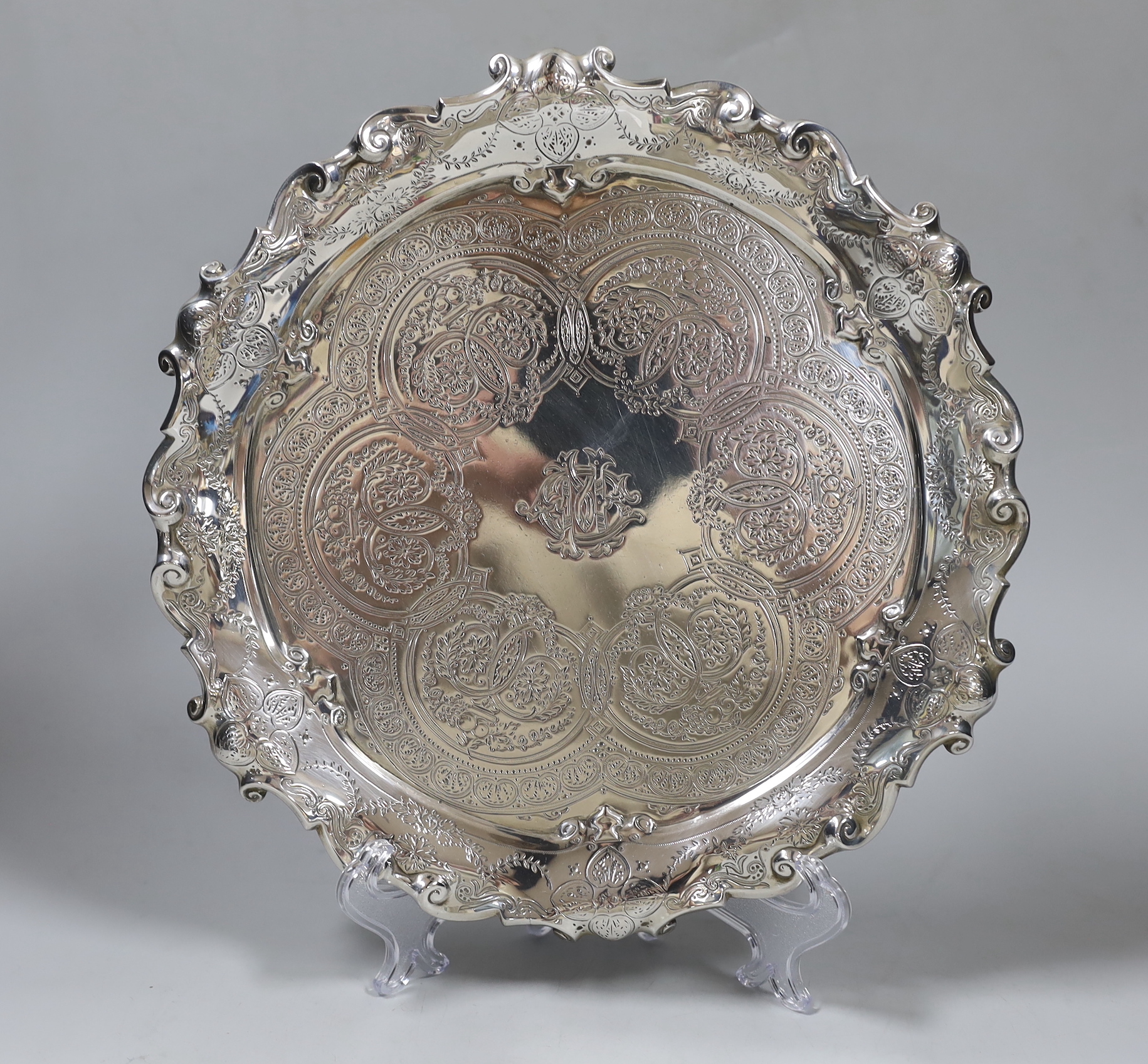 A late Victorian engraved silver salver, with wavy scroll border, Goldsmiths & Silversmiths Co, London, 1893, 25.6cm, 17.2oz.